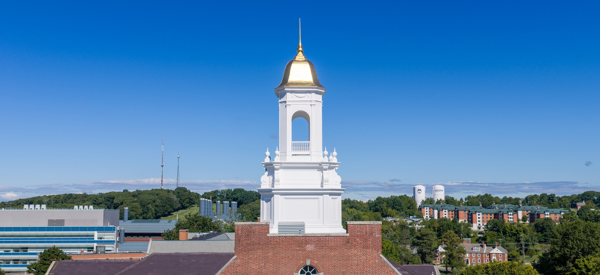 blue sky, with a white cupola and gold dorm
